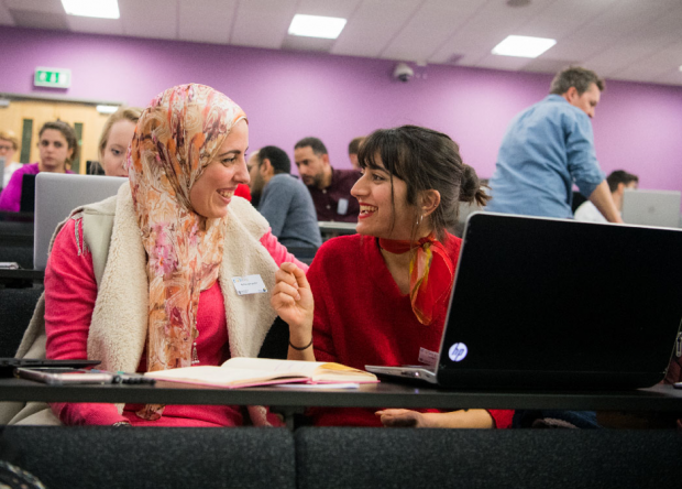 Image of two women undertaking a digital skills training course in conversation.